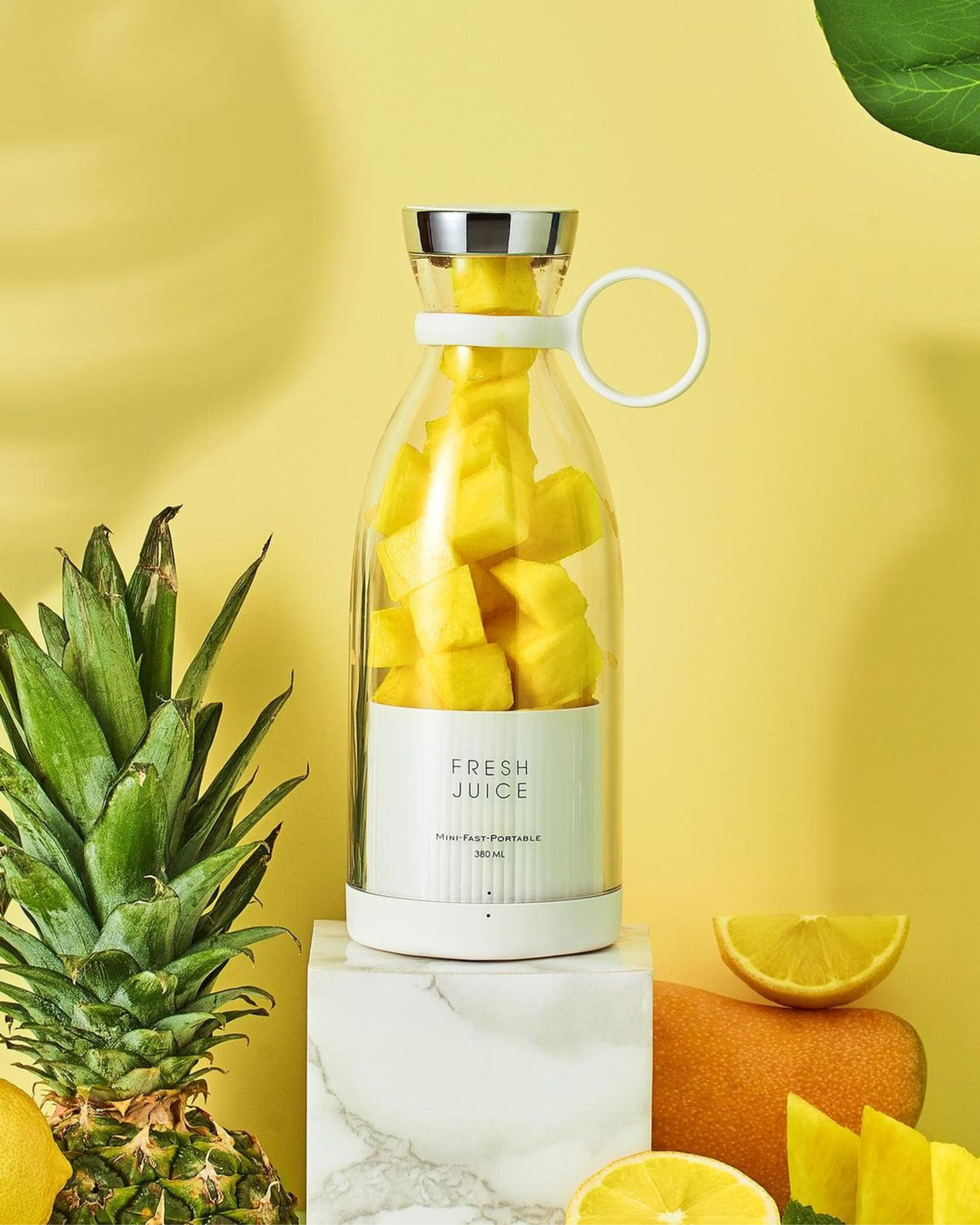 Bottle filled with pineapple chunks on a yellow background